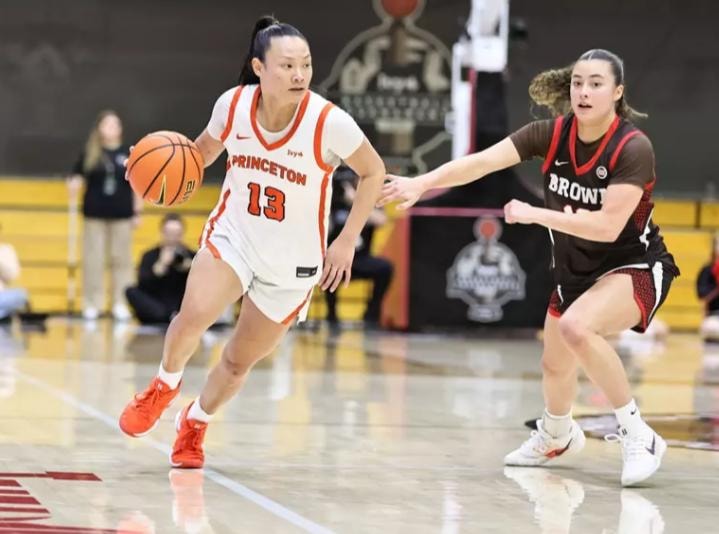 Princeton player #13 driving past a Brown defender
