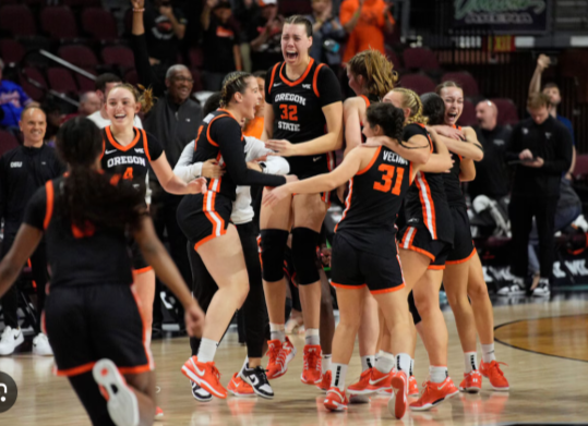 Oregon State women's basketball players celebrating on court — the first women's college sports team to file for union representation
